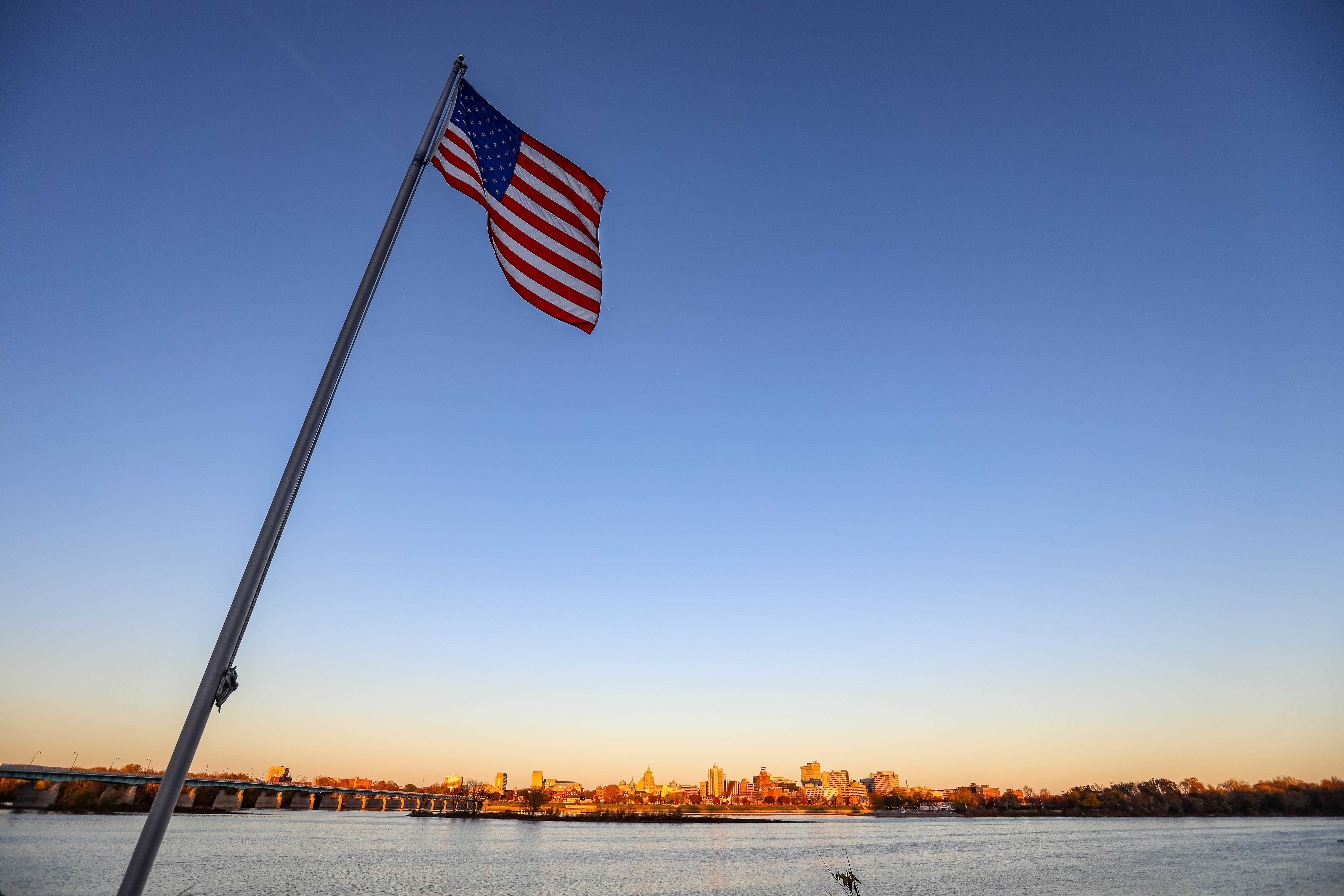 Flag flies over Susquehanna River at sunset